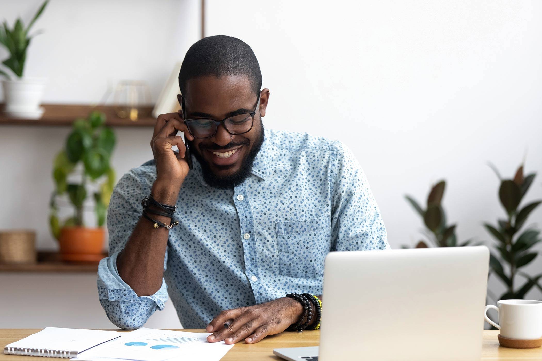 Black male office worker on mobile phone.